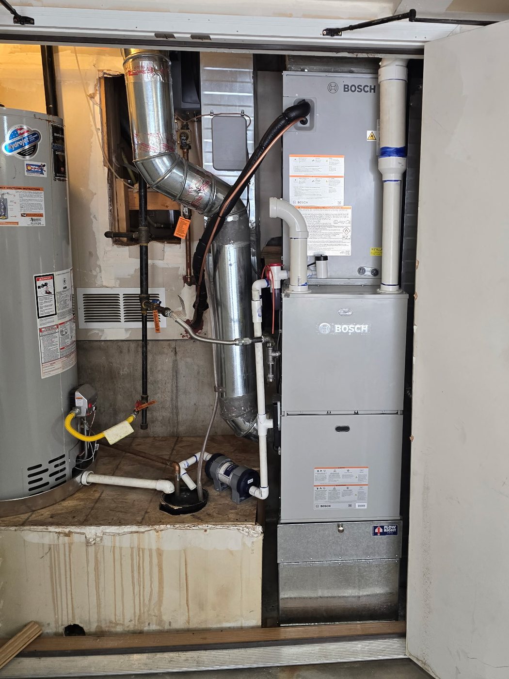 Heat pump installation: Bosch indoor unit with new PVC venting, an insulated refrigerant line set and a condensate pump in a garage mechanical closet